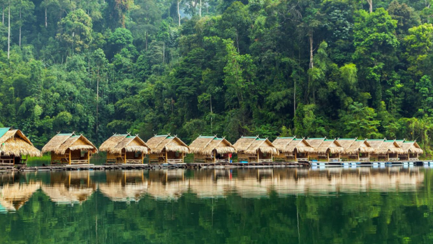 Floating bungalows on Cheow Lan Lake with mountains in the background