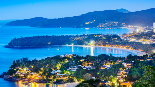 Coastal beach with clear blue sea and tall buildings in the background
