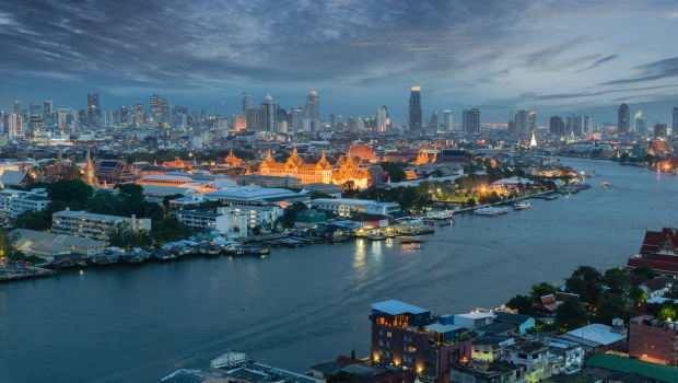 Temple illuminated at night with reflections shimmering on the river