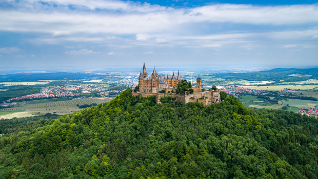 Hohenzollern Castle sitting high on a forested hilltop with panoramic views of Baden-Württemberg, Germany.
