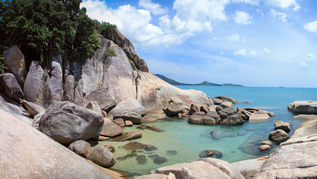 clear turquoise water surrounded by big smooth boulders