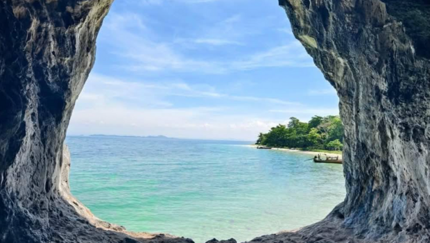 ocean framed by a rocky cave opening, clear blue water outside