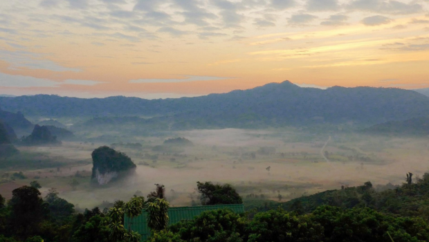 soft morning fog over hills and fields at sunrise