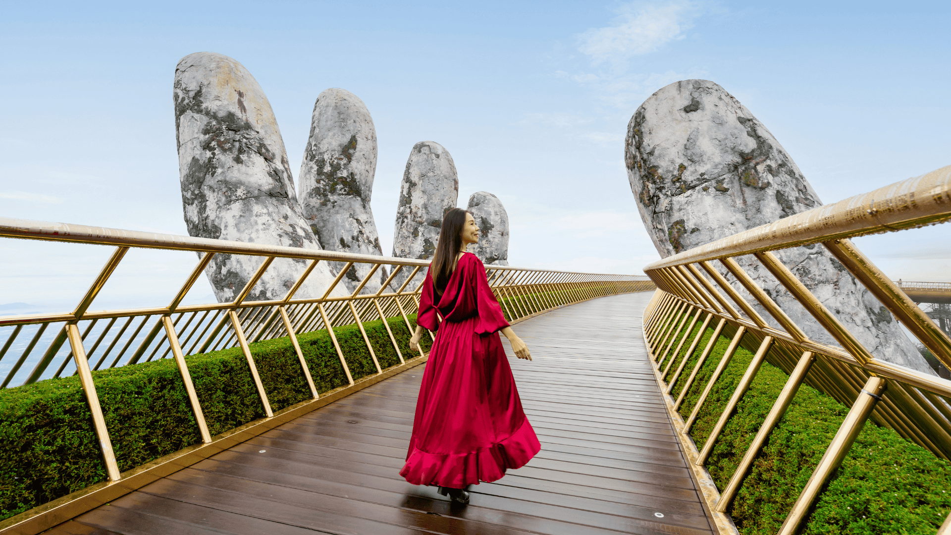 นักท่องเที่ยวเดินบนสะพานมือหินทองที่บานาฮิลส์ เวียดนาม รายล้อมด้วยมือหินยักษ์และวิวภูเขา