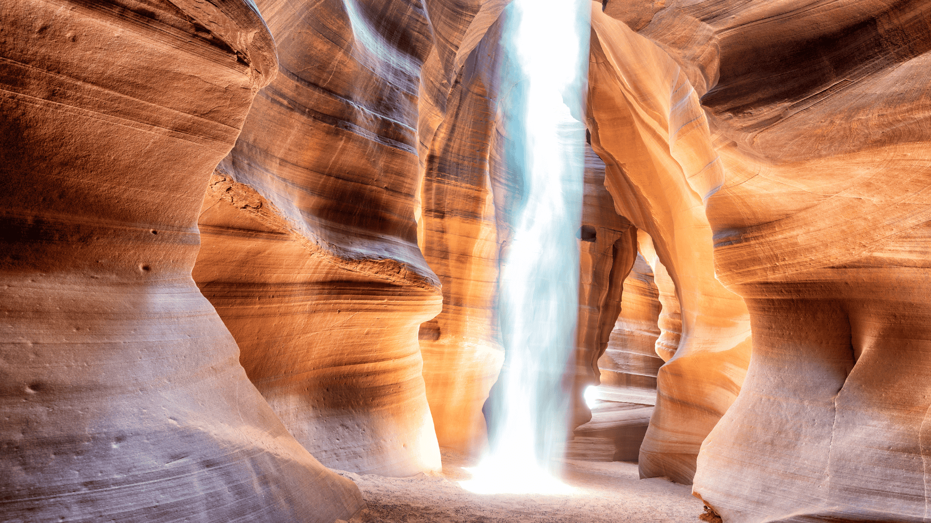 ช่องแคบหินทรายของ Antelope Canyon พร้อมลำแสงธรรมชาติสาดส่องลงมาตรงกลางหุบเขา